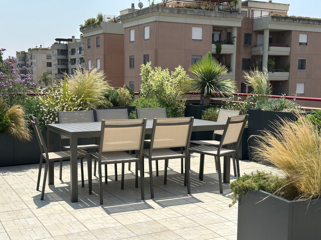 Terrazza Torrino design contemporaneo con graminacee, sedie rosse, ortensie e vasi neri, AbitoVerde Roma
