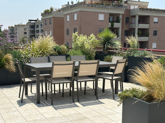 Terrazza Torrino design contemporaneo con graminacee, sedie rosse, ortensie e vasi neri, AbitoVerde Roma