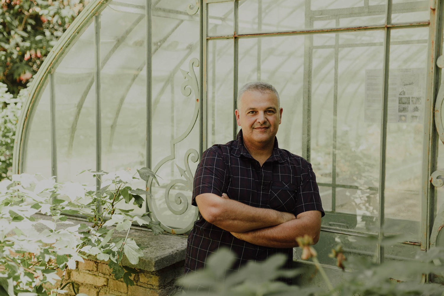 Andrea Molinaro progettista giardini AbitoVerde davanti cancello decorativo verde, ritratto professionale