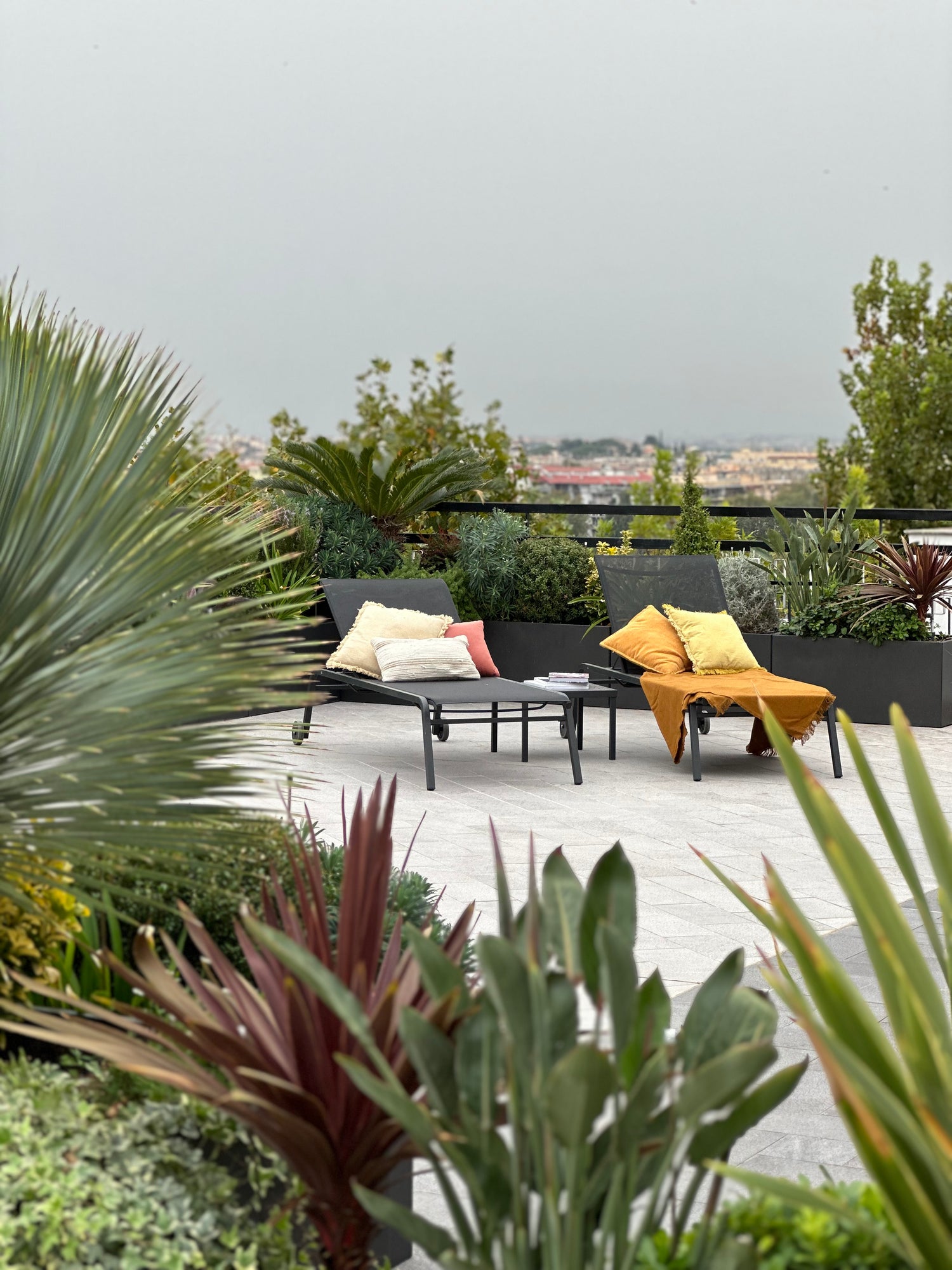 Progettazione terrazza rooftop con poltrone relax arancioni, piante succulente e vista panoramica, AbitoVerde