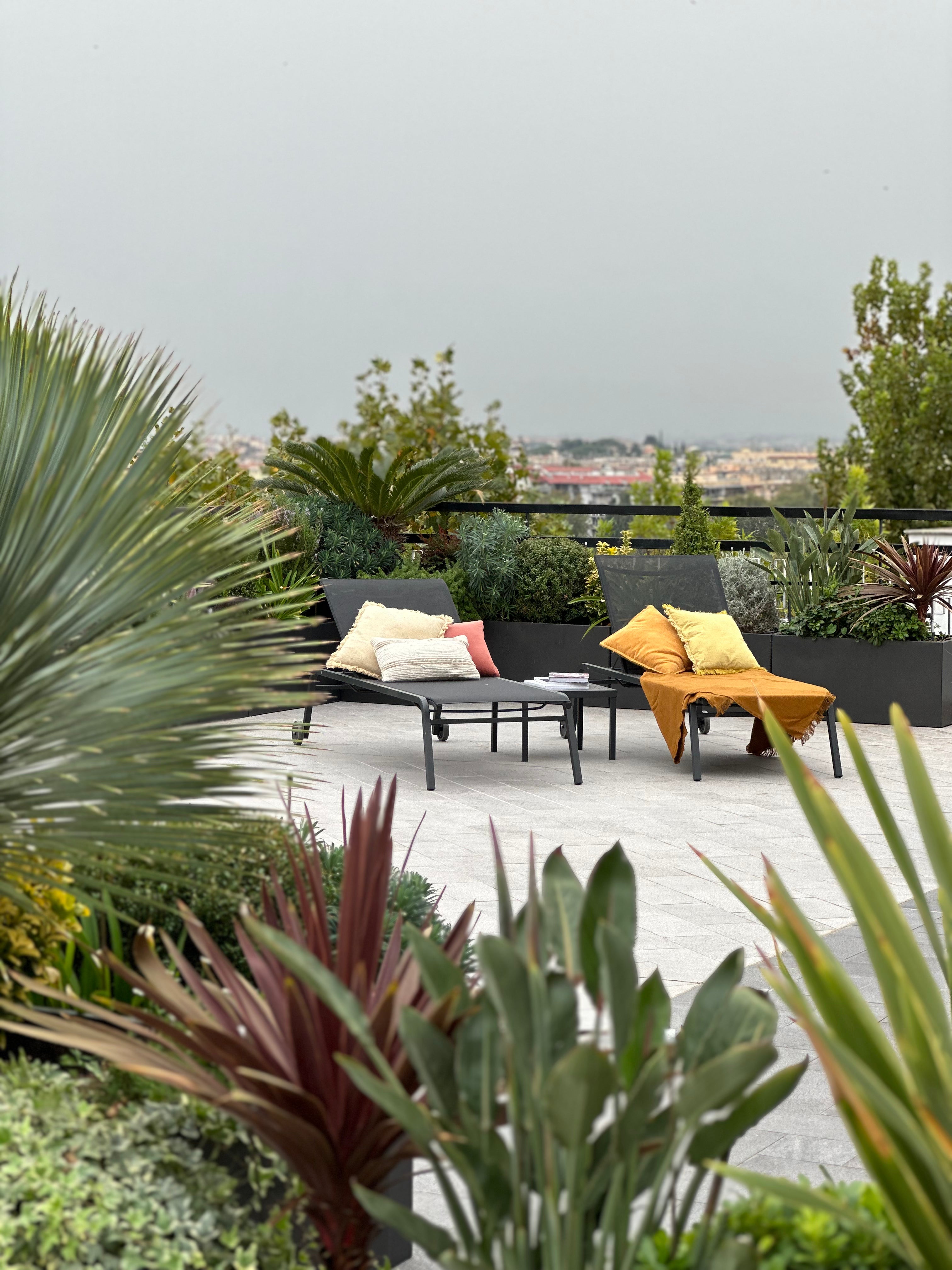 Progettazione terrazza rooftop con poltrone relax arancioni, piante succulente e vista panoramica, AbitoVerde